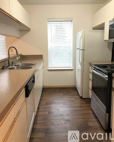 A kitchen with a white fridge and black oven.