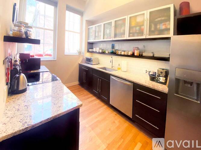 A kitchen with a granite counter top and stainless steel appliances.