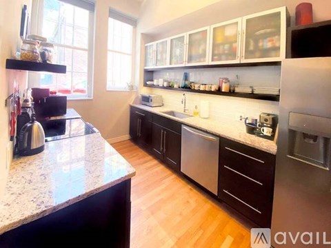 A kitchen with a granite counter top and stainless steel appliances.