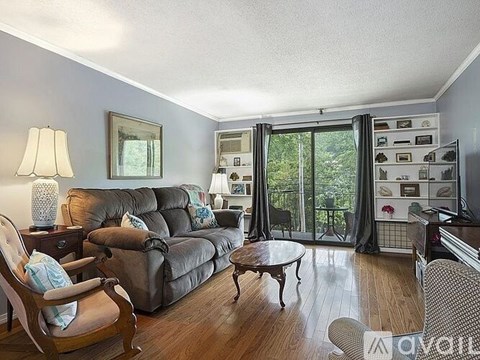 A living room with a brown leather couch and a wooden coffee table.