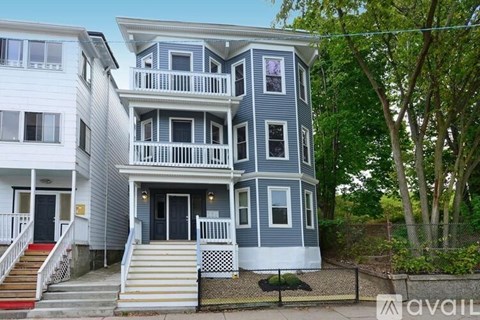 A two-story house with a balcony on the second floor.