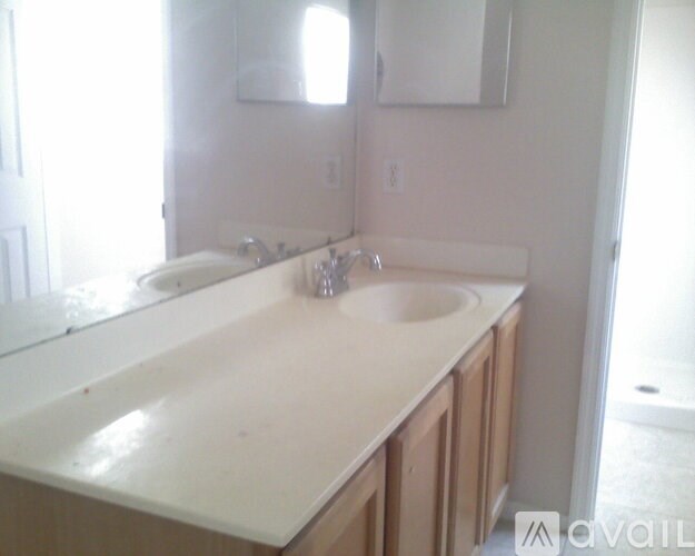 A bathroom with a white counter top and a large mirror.