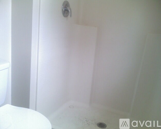 A white bathroom with a tub and toilet.