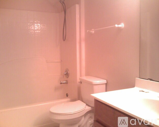 A white toilet sits next to a white bathtub in a bathroom.