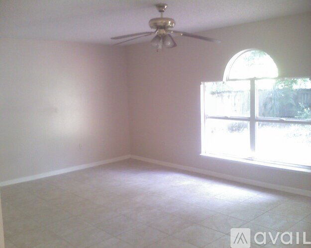 A room with a ceiling fan and a window.