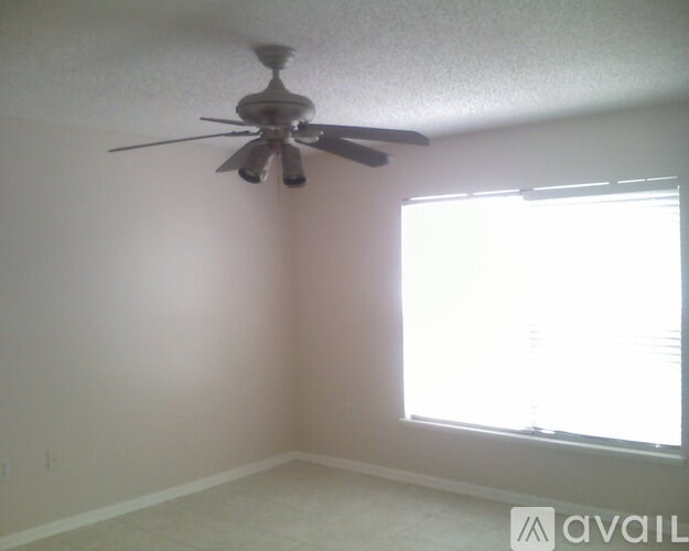 A room with a ceiling fan and a window.