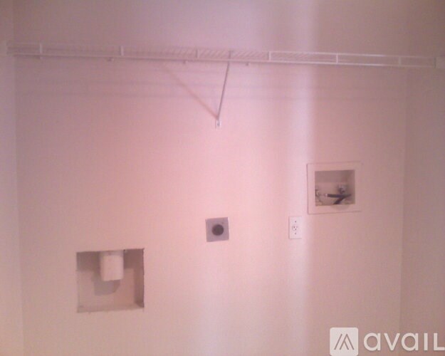 A white wall with a picture and a light switch.