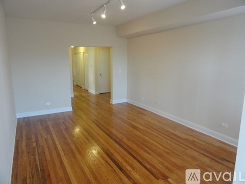 A room with wooden flooring and white walls.