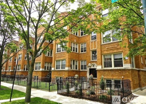 A brick building with a black fence in front.