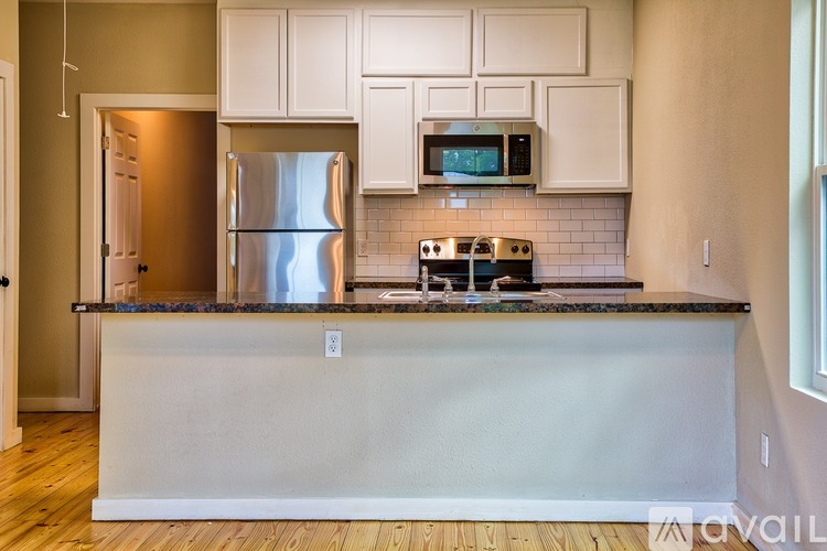 A kitchen with a refrigerator, microwave, and oven.