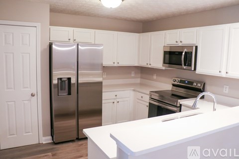 A kitchen with white cabinets and a white counter top.