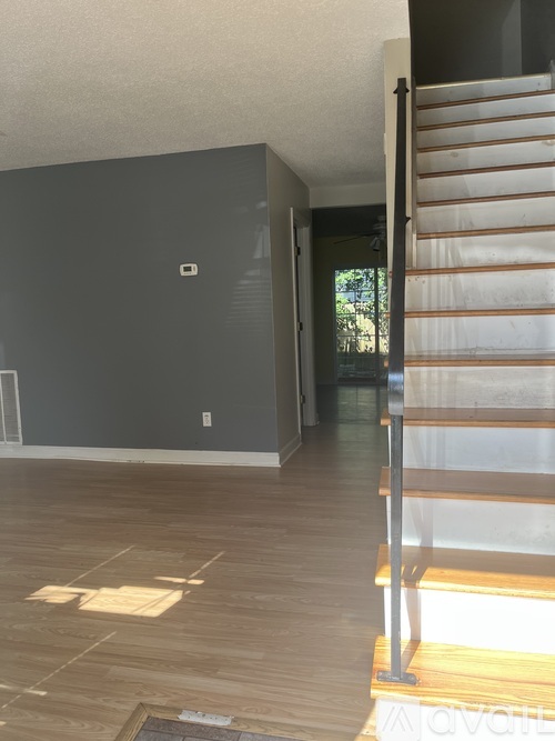 A room with a window and carpeted floor.