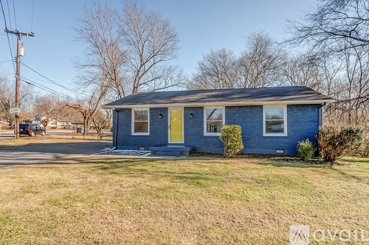A blue house with a yellow door is for sale.