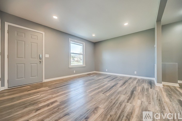 A room with wooden flooring and a white door.