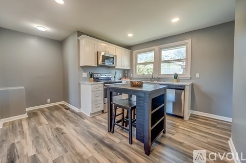 A kitchen with a table and chairs in the middle of the room.