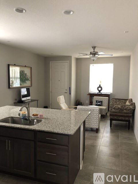 A kitchen with a sink and a fan on the ceiling.