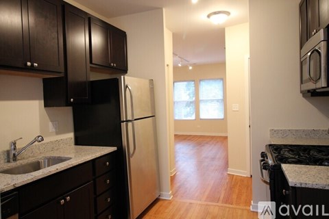 A kitchen with black cabinets and a black fridge.