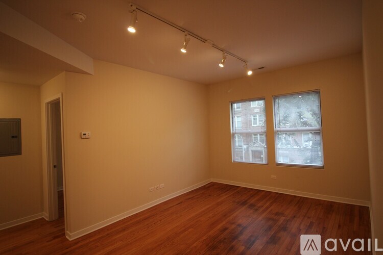 A room with wooden floors and two windows.