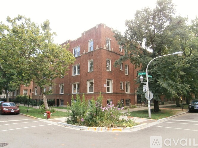 A red brick building with a green lawn in front.