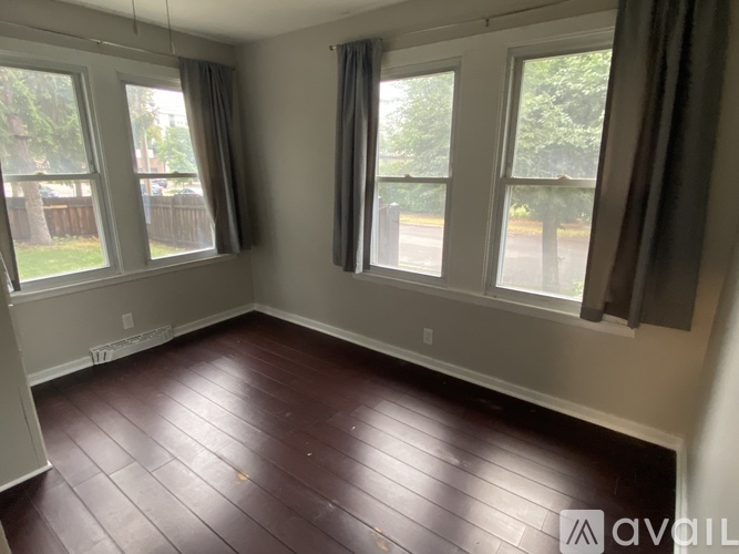 A room with two windows and a wooden floor.