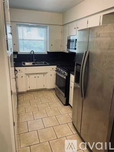 A kitchen with a black countertop and white cabinets.