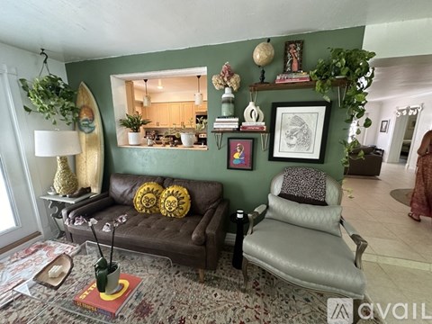 A living room with a brown couch, a grey chair, and a rug with a red book on it.