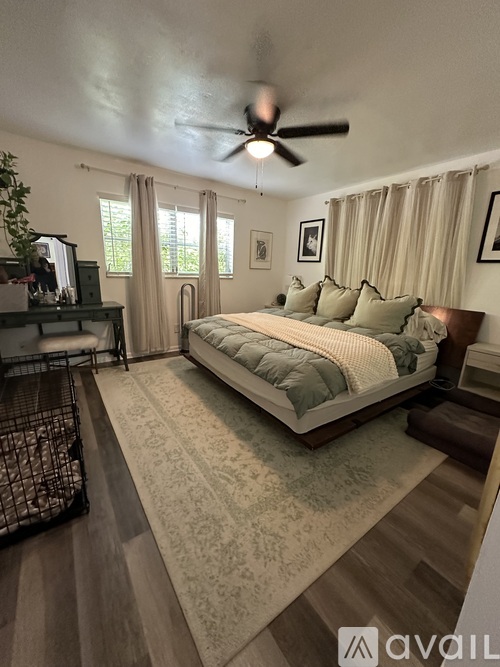 A bedroom with a large bed and a ceiling fan.