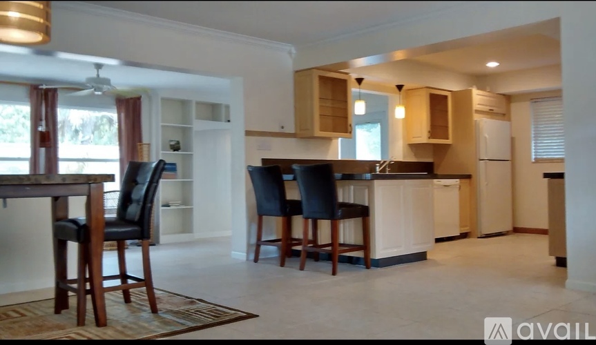 A kitchen with a table and chairs in front of it.