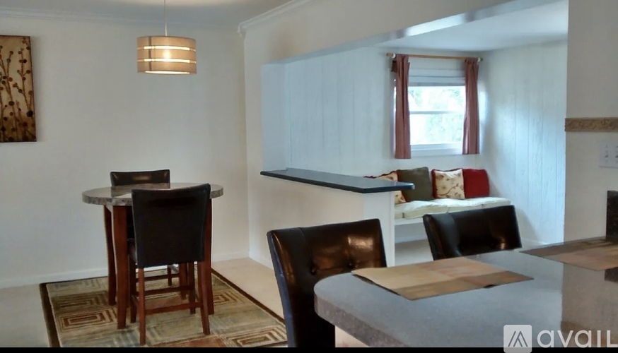 A dining room with a table and chairs.