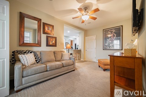 A living room with a grey couch and a wooden dresser.