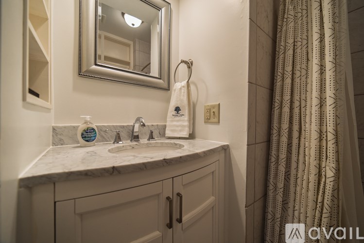 A bathroom with a marble countertop and a large mirror.
