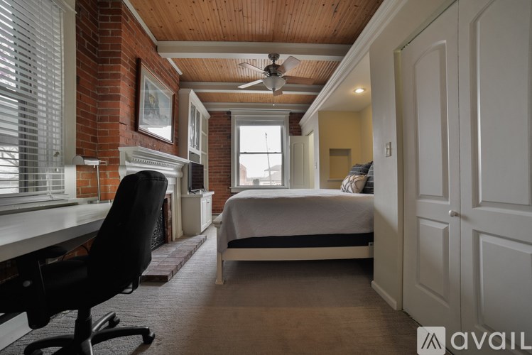 A bedroom with a bed, desk, and chair.