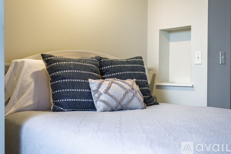 A bed with a white sheet and two striped pillows.