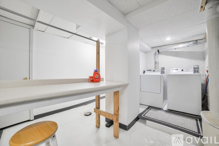 A room with a white wall and a white floor with a red toy on the table.