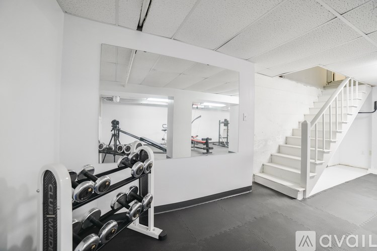 A gym with a row of dumbbells and a mirror.
