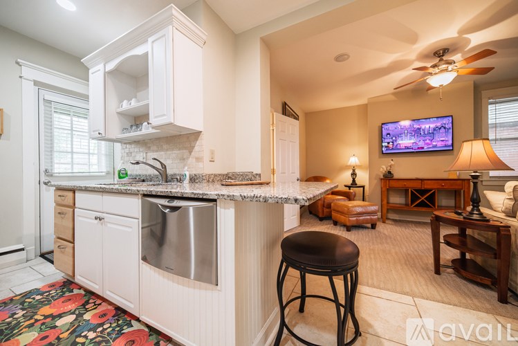 A kitchen with a bar stool in front of it.
