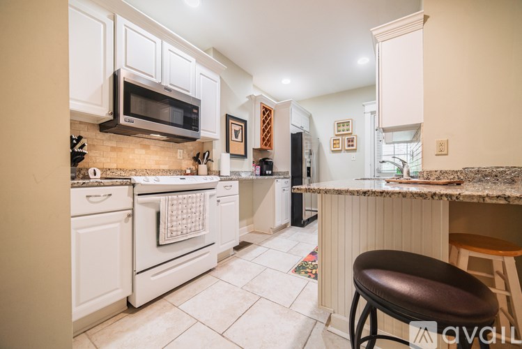 A kitchen with white appliances and cabinets.
