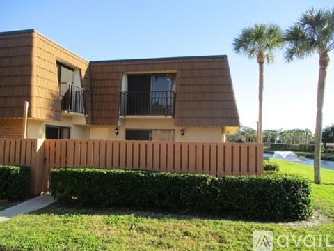 A house with a brown roof and a wooden fence.