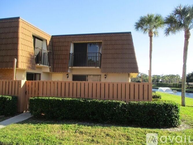A house with a brown roof and a wooden fence.