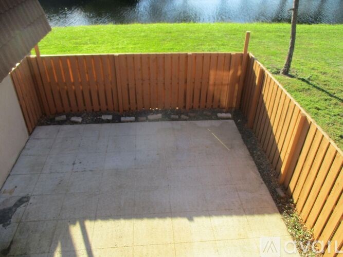 A wooden deck with a tiled floor and a grassy area in the background.
