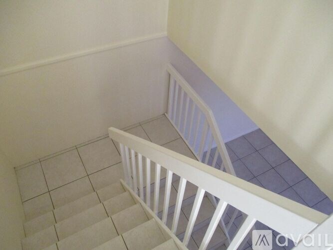 A staircase with a white railing and tiled steps.