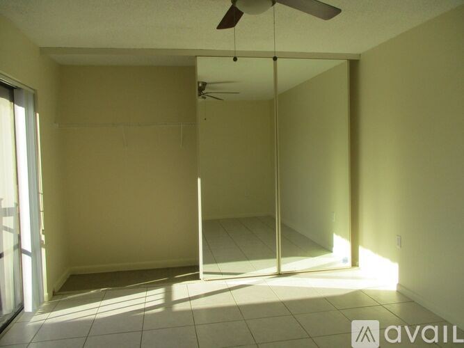 A room with a ceiling fan and sliding glass doors.