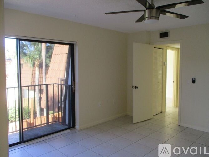 A room with a ceiling fan and sliding glass doors.