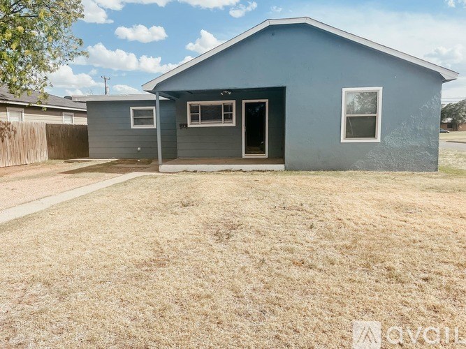 A blue house with a brown fence and a brown lawn.