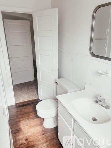 A white toilet and sink in a small bathroom.