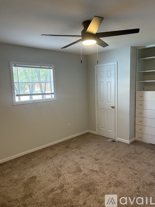 A room with a ceiling fan and a window.