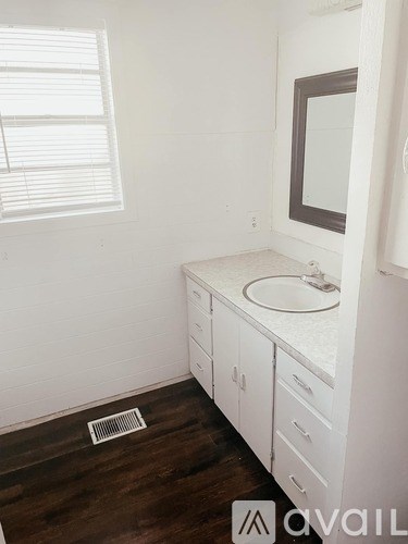 A bathroom with a sink and a window.