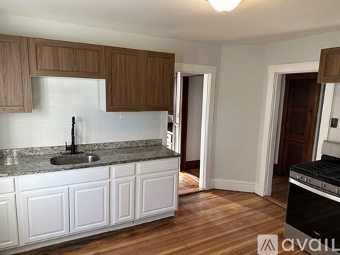 A kitchen with white cabinets and a black stove top oven.