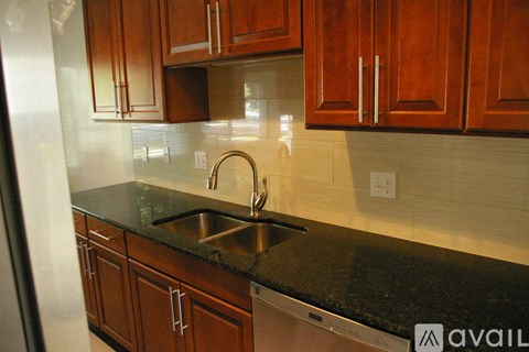 A kitchen with wooden cabinets and a black countertop.