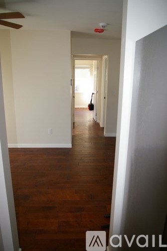 A hallway with wood floors and a ceiling fan.